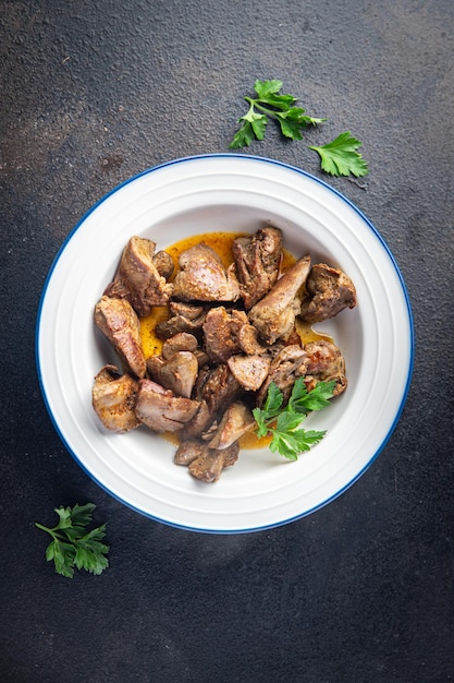 Comida de fígado de frango frito ou refogado de miudezas na mesa copie o espaço