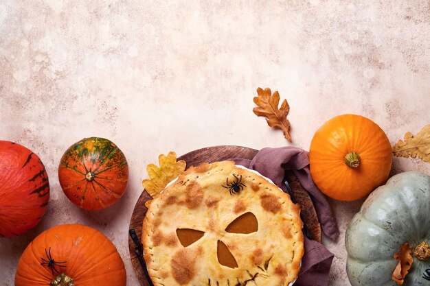 Comida de Halloween. Torta de abóbora caseira ou torta com uma cara assustadora para o Halloween em uma mesa de madeira. Copie o espaço. Conceito de comida de Halloween.