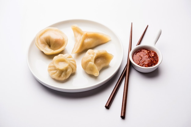 Comida de momos de bolinho tradicional do Nepal servido com chutney de tomate sobre um fundo temperamental. Foco seletivo