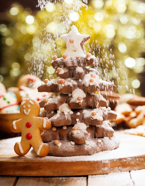 Comida de Natal. Árvore de Natal feita de biscoitos de gengibre e neve de açúcar de confeiteiro no fundo desfocado