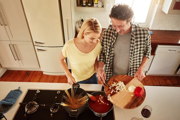 Comida de vista superior ou casal feliz em uma cozinha cozinhando com vegetais saudáveis para o jantar juntos em casa Amor ou mulher ajudando ou conversando com marido maduro na preparação da dieta do almoço na Austrália