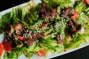 Foto comida deliciosa: carne cozida lenta puxada com close-up de salada de vegetais frescos em um prato.