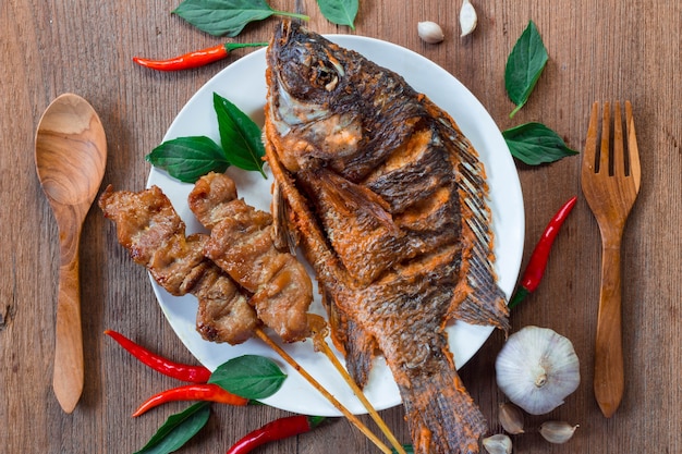 Comida deliciosa com peixe frito e carne de porco assada