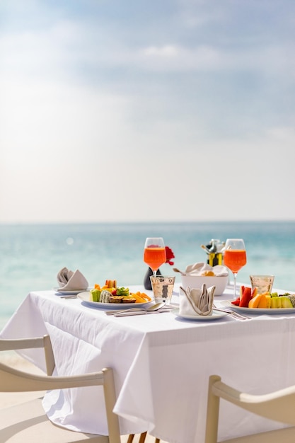 Comida de desayuno de lujo en una mesa blanca, con un hermoso fondo tropical con vistas al mar, hora de la mañana