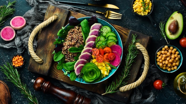 Comida dietética Quinoa sandía rábano pepino tomates y espinacas Tazón Buda Comida vegana Vista superior Sobre un fondo de piedra