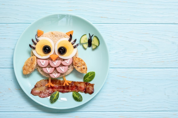 Foto comida divertida para niños: linda tostada de sándwich de búho con salchichas y huevos