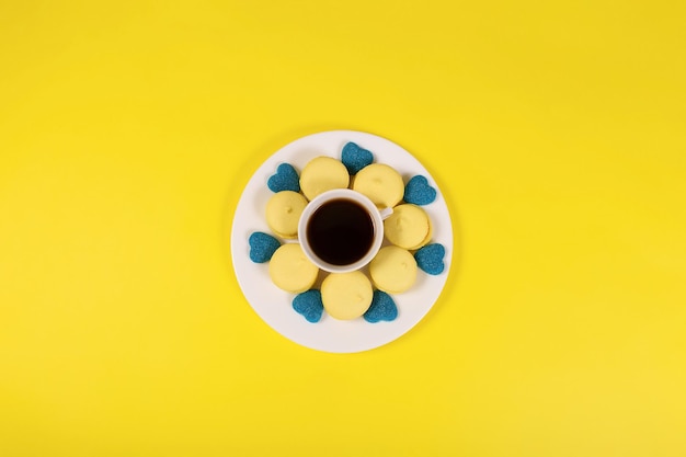 Comida doce e uma xícara de café em um fundo amarelo Alimentos e bebidas