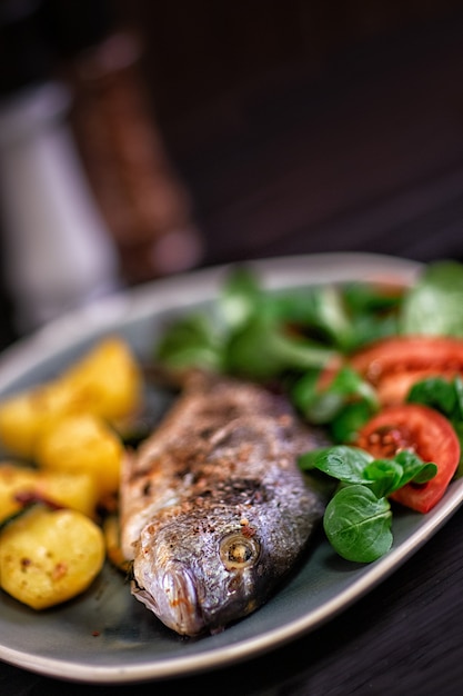 Comida Dorado al horno con verduras en el horno sobre un fondo oscuro.