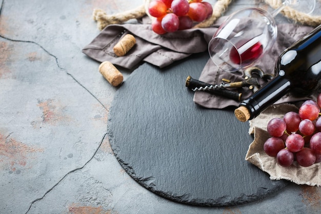 Comida e bebida férias ainda vida colheita sazonal outono conceito de outono Garrafa saca-rolhas rolhas copo de vinho tinto e uvas em uma mesa grunge Copie o fundo do espaço