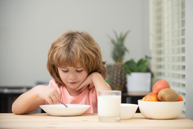 Comida e bebida para crianças caucasiano criança menino comendo sopa saudável na cozinha