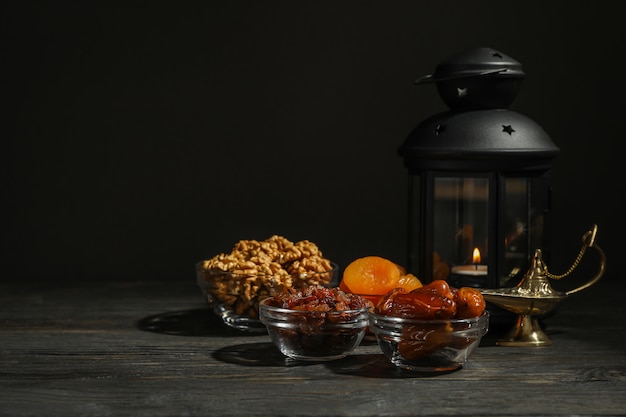 Foto comida e decoração de ramadan kareem na mesa de madeira contra o fundo escuro