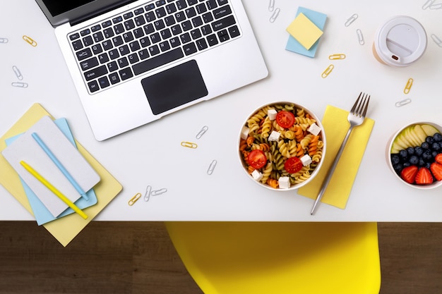 Comida em tirar caixas na mesa branca com laptop. Entrega de comida online.