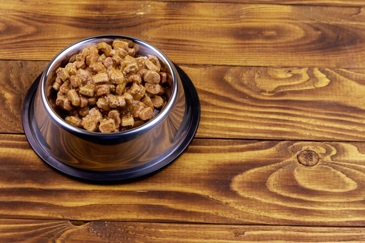 Foto comida enlatada para gatos ou cães em tigela de metal no piso de madeira