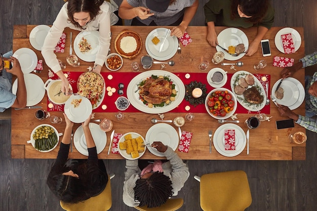 La comida facilita la reunión Toma de un grupo de personas sentadas juntas en una mesa de comedor listas para comer