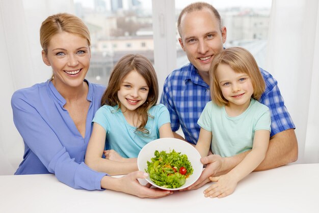 comida, família, crianças, felicidade e conceito de pessoas - família feliz com dois filhos com salada em casa