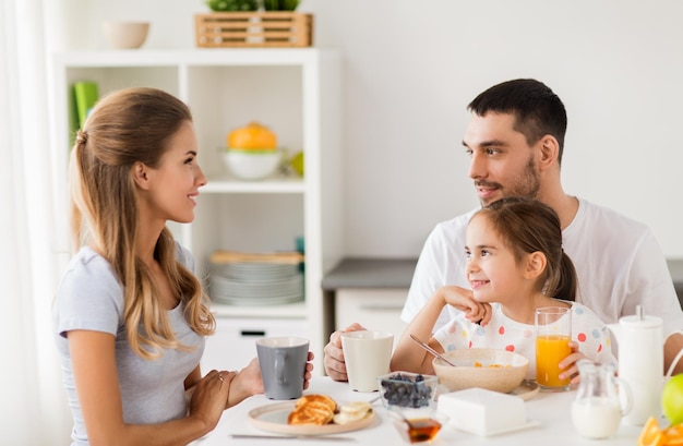 Foto comida familiar y concepto de personas madre feliz padre e hija desayunando en casa