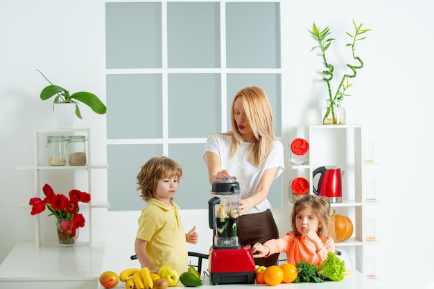 Comida familiar saudável Mãe filha e filho preparando smoothie saudável na cozinha moderna