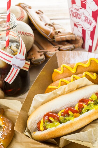 Foto comida de fiesta de béisbol con pelotas y guante en una mesa de madera.