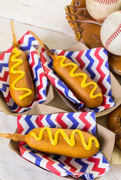 Comida de fiesta de béisbol con pelotas y guante en una mesa de madera.