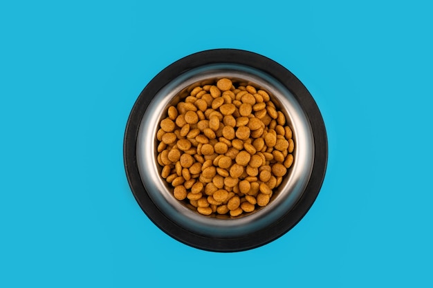 Foto comida para gatos y perros en un recipiente sobre un fondo azul... vista superior.