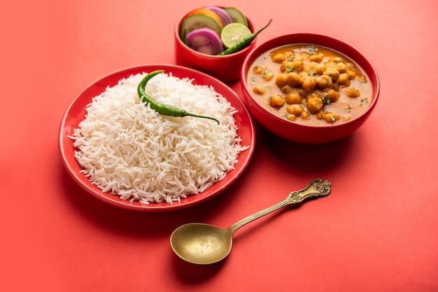 Comida india chole chawal o curry picante de garbanzos con arroz simple servido con ensalada verde