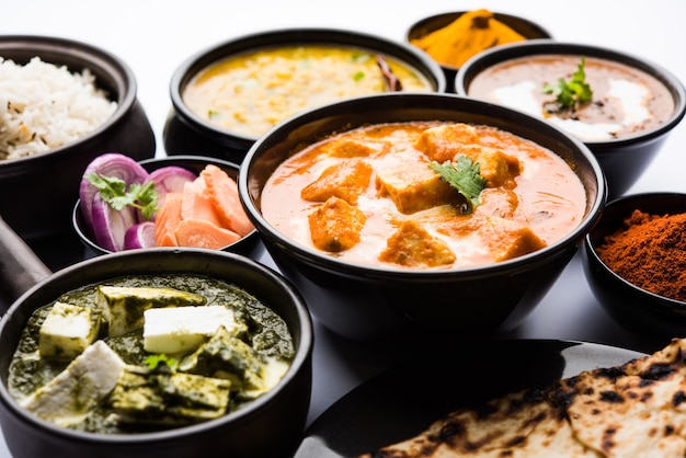 La comida india del plato principal del almuerzo o la cena en grupo incluye Paneer Butter Masala, Dal Makhani, Palak Paneer, Roti, Rice, etc., enfoque selectivo