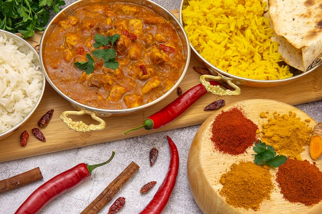 Comida india. Pollo al curry en salsa de tomate con arroz blanco y amarillo, especias: curry, cúrcuma, pimentón picante y suave