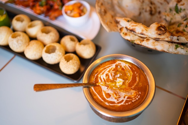Comida india Pollo con mantequilla al curry Palak Paneer Chiken Tikka Biryani Curry vegetal Papad Dal Palak Sabji Jira Alu Arroz con azafrán en la mesa