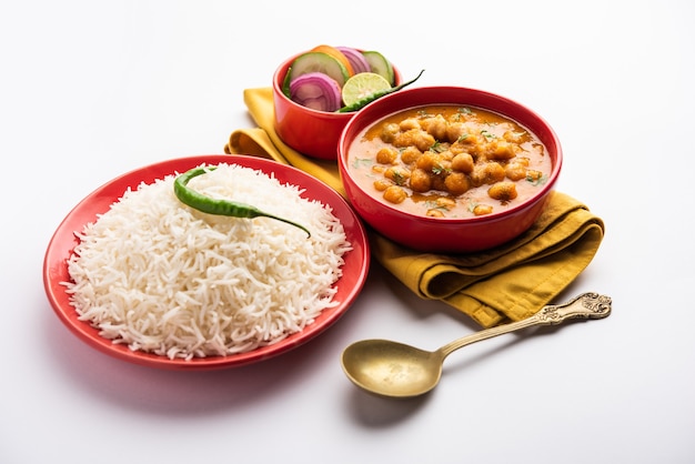 Comida indiana chole chawal ou curry picante de grão de bico com arroz puro servido com salada verde