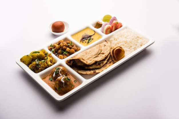Comida indiana vegetariana Thali ou Parcel bandeja com compartimentos em que Malai Kofta, chole, Dal tarka, dry aloo sabji, chapati e arroz com doce gulab jamun servido