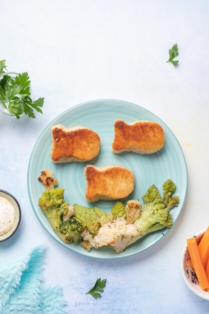 Comida infantil nuggets em forma de peixe com vegetais