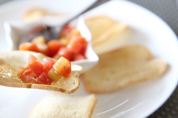 Comida italiana de aperitivos, fatias de bruschetta de baguete torrada guarnecida com manjericão e tomate