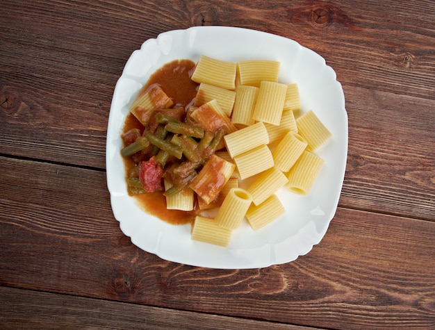 Comida italiana. macarrão rigatoni com feijão verde e molho de tomate