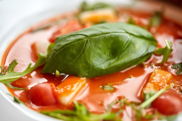 comida, jantar, culinária, alta cozinha e conceito de cozinha - close up de prato com deliciosa sopa de gazpacho no restaurante