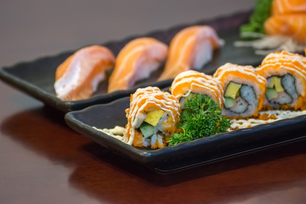 Comida japonesa en conjunto diferentes tipos de sushi con ensalada de algas y gari (jengibre)