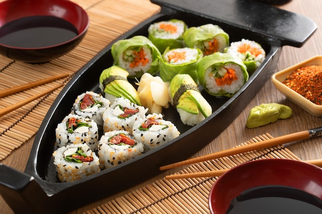 Comida japonesa e cebolas crocantes servidas no restaurante em barco preto na mesa de madeira