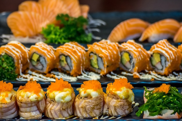 Comida japonesa em conjunto diferentes tipos de sushi com salada de algas e gari (gengibre)