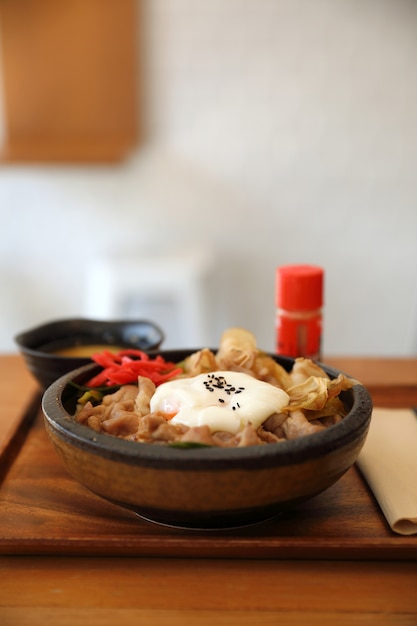 Comida japonesa Gyudon Ternera japonesa en un tazón de arroz con huevo en una mesa de madera