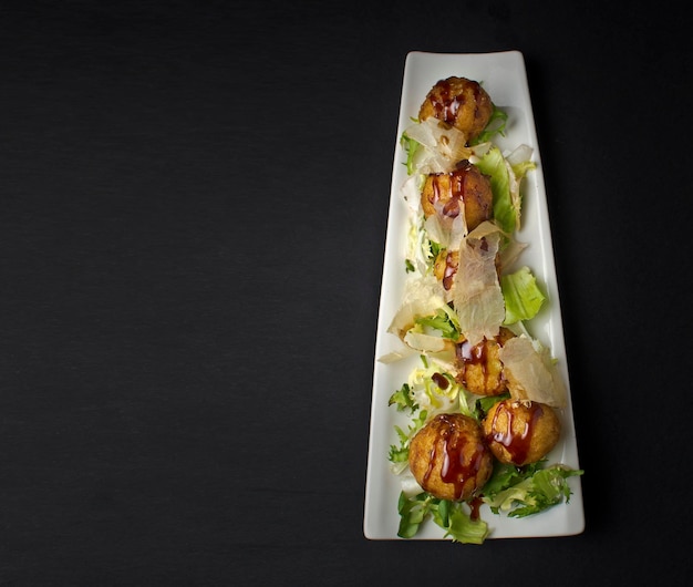 Foto comida japonesa en un plato blanco sobre fondo negro vista superior banner