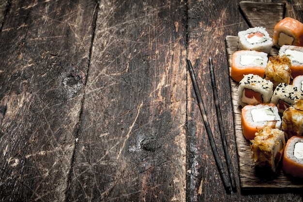 Comida japonesa. Rollos de mariscos frescos con un palillo. En el fondo de madera vieja.