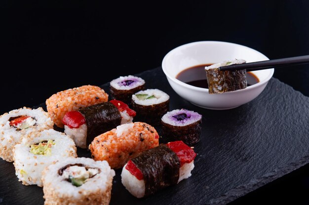 comida japonesa con rollos de sushi vegetariano con remolacha y pepino con palillos negros