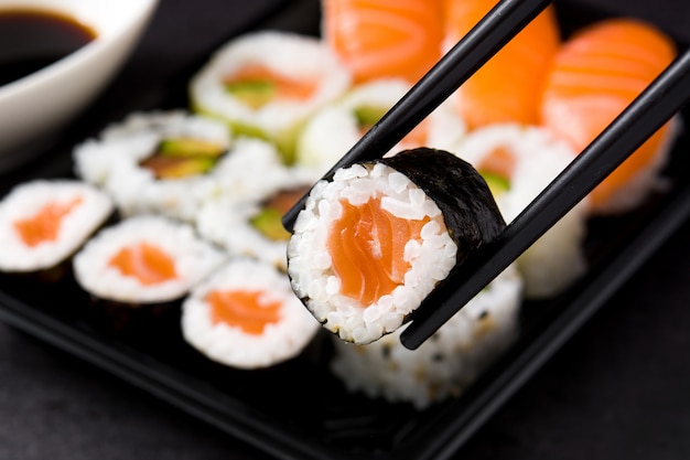 Comida japonesa: sushi maki y nigiri en negro, primer plano