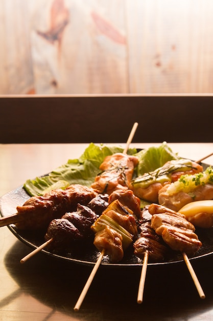 Foto comida japonesa. yakitori. carne marinada em molho no espeto e grelhada no carvão.