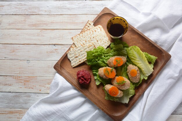 Comida judía tradicional de Pascua: pescado gefilte con zanahorias, lechuga, rábano picante y matzá