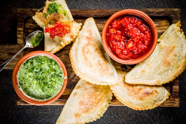 Comida latinoamericana, mexicana, chilena. Empanadas de pastelería tradicional al horno con carne de res, dos salsas picantes