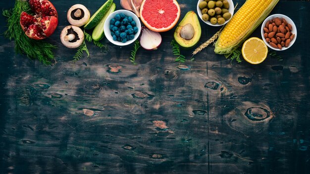 Comida Legumes frutas nozes e bagas Vitaminas em uma velha mesa de madeira Vista superior Espaço livre para texto