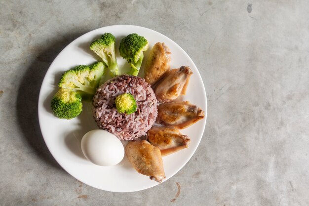 Comida limpia, pollo frito, vegetales con brócoli, huevo y arroz