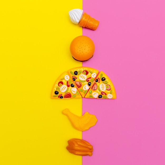 Comida lixo de brinquedo em fundo colorido. fast food flat lay arte minimal