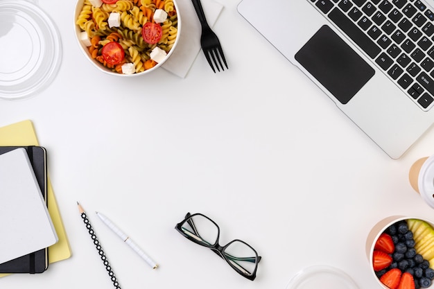 Comida para llevar cajas en mesa blanca con laptop