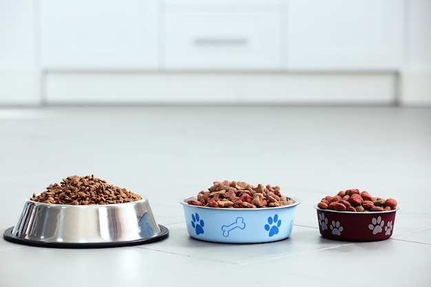 Foto comida para mascotas en tazones de metal en el piso